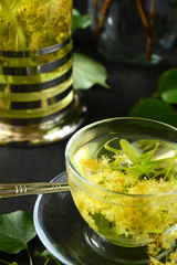 Linden tea in glass cup on dark wooden background
