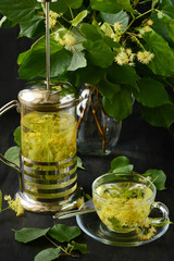 Linden tea in glass cup on dark wooden background
