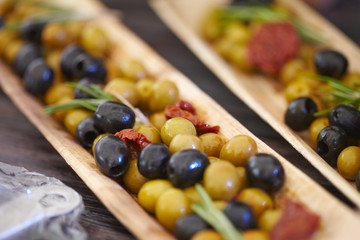 black and green olives, herbs, sun-dried tomatoes in an oblong d