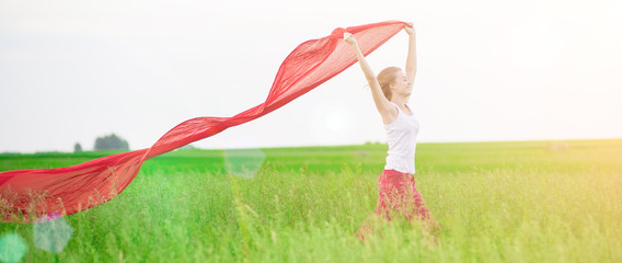 Young lady runing with tissue in green field. Woman and red