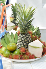 banana, rambutan, coconut, orange and pineapple in zinc salver