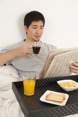 Man having a breakfast while reading the newspaper