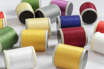 Several bobbins of cotton thread for sewing machines on white background