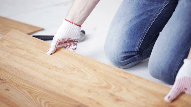 close up of man installing wood flooring