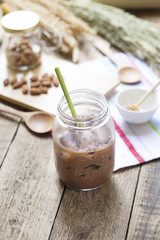 Obraz na płótnie Canvas Cold Chocolate Milk drink (close-up shot) on wooden background