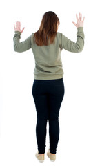 back view of woman  protects hands from what is falling from abo