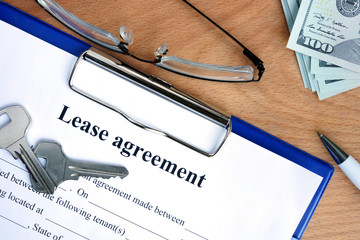 Lease agreement document with money on a wood background