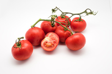  Red and fresh tomatoes on the vine isolated on white