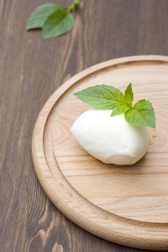 Mozzarella with herbs on a round wooden board