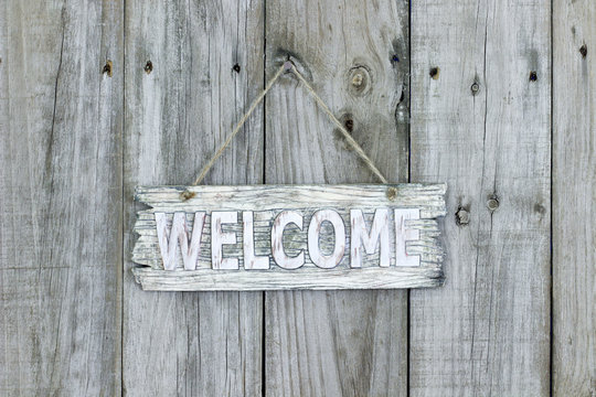 Rustic welcome sign hanging on wood background