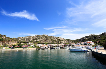 Fototapeta na wymiar Beautiful small Sardinian port Poltu Quatu and mountains