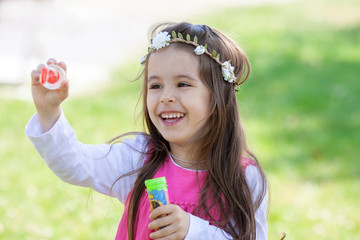 Beautiful portrait of sweet lovely little girl blowing soap bubb © Tomsickova