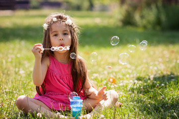 Beautiful portrait of sweet lovely little girl blowing soap bubb © Tomsickova