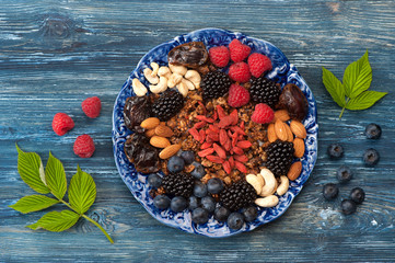 ingredients for a healthy breakfast - oat granola, berries, goji berries and nuts. Top view,...