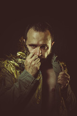 Man with golden jacket and large feathers on his lapel