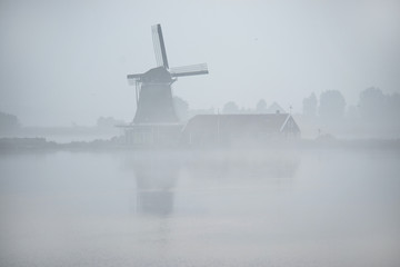 Fototapeta na wymiar windmills in morning fog the Netherlands, Zaanse Schans