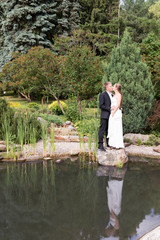Bride and groom standing at the water