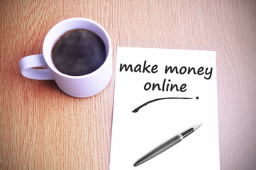 Obraz na płótnie Canvas Coffee on the table with note writing make money online