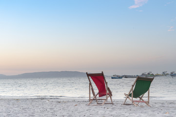 Beach chair on sand beach while beautiful sunset. Concept of rel