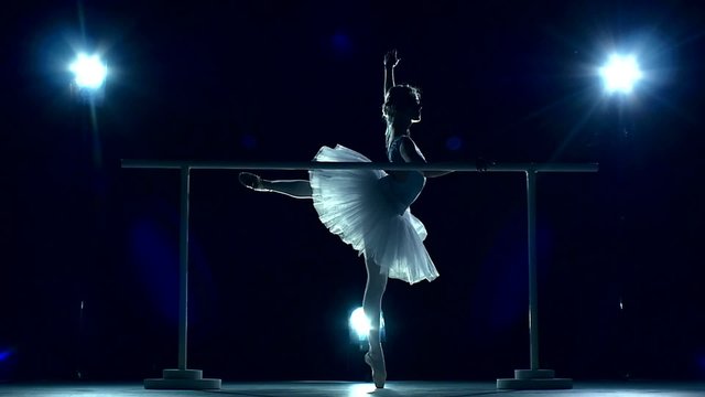 Ballerina is wearing white tutu and pointe shoes. slow motion