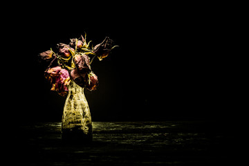 Flowers in a vase on wood black background