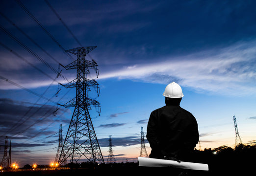silhouette of engineers standing at electricity station