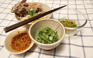 coriander and chili in the bowls with dry noodle background