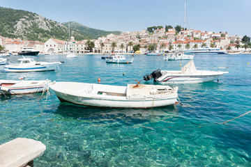 Idyllic Mediterranean ,luxury pleasure boats in Starigrad harbor of historic town with white buildings terracotta tiles around the shore and rolling green hills.,Hvar, Croatia.