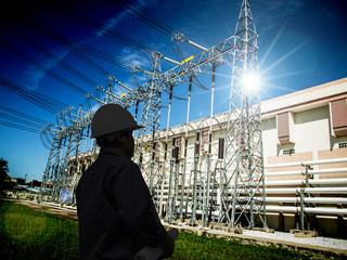silhouette of engineers standing at electricity station