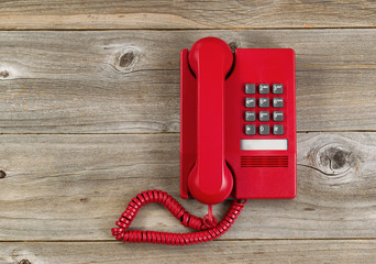 Vintage red phone on rustic wooden boards