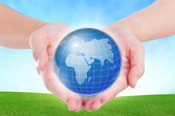 Female hands holding on earth global on grassland.