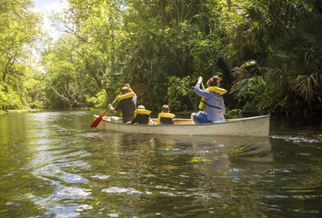 Fototapeta na wymiar Family canoe ride down a beautiful tropical river