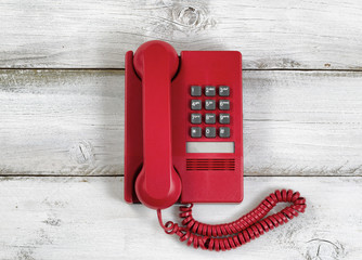 Vintage red phone on rustic white wooden boards