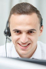 Call center male operator with phone headset working at the office
