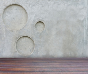 wood floor and gray concrete wall with circle pitted texture bac