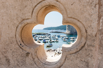 Dubrovnik harbor through feature opening in ancient wall.