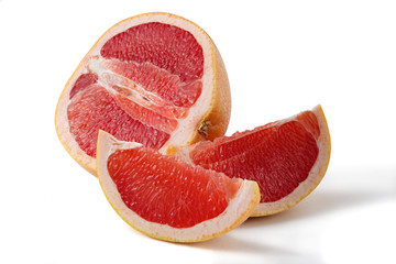 pink grapefruit half and two slices on a white background