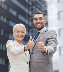 smiling businessmen showing thumbs up