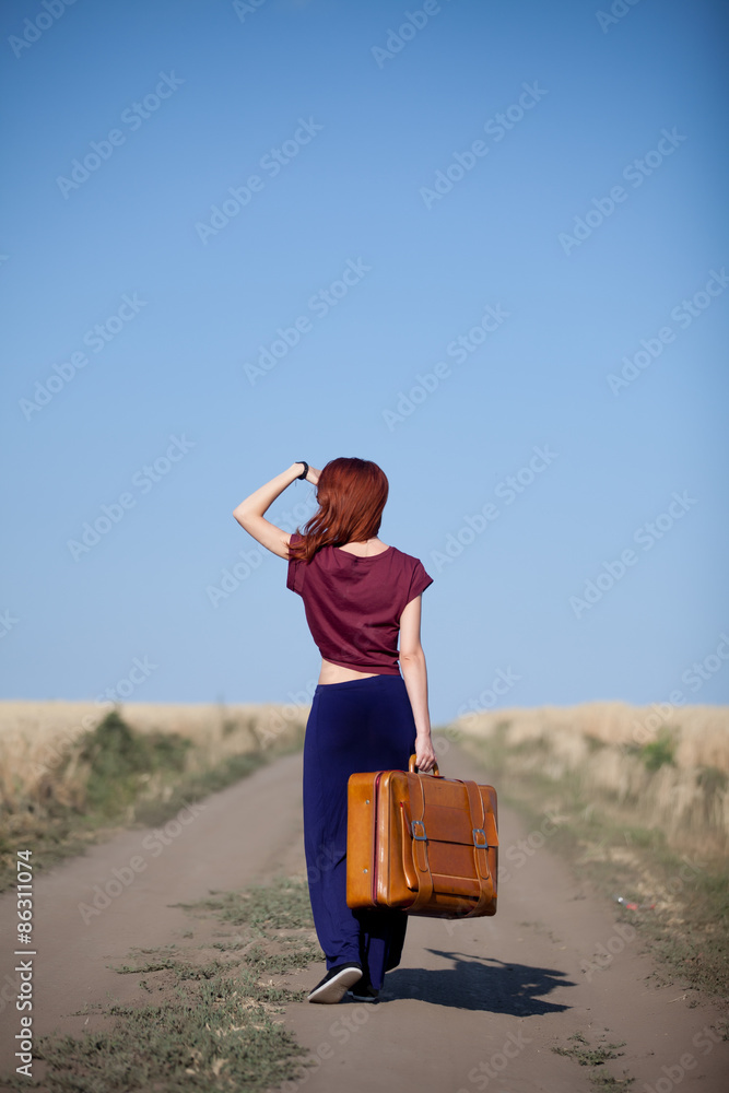 Sticker redhead girl with suitcase at countryside road