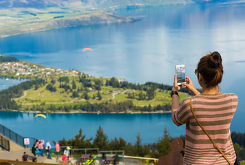 Young adult woman using her smart phone capturing her wonderful © naruedom