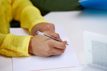 close up of female hands writing to notebook