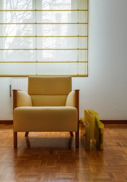 Sill&oacute;n con revistero junto a una ventana