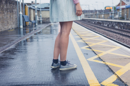 Legs of young woman standing on platform