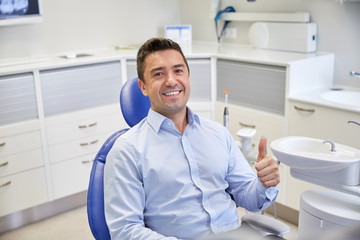 happy man showing thumbs up at dental clinic
