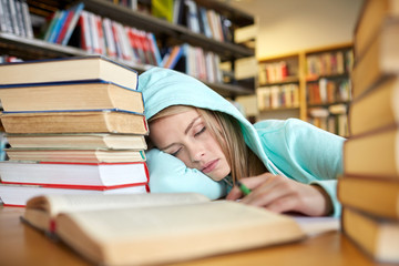 student or woman with books sleeping in library