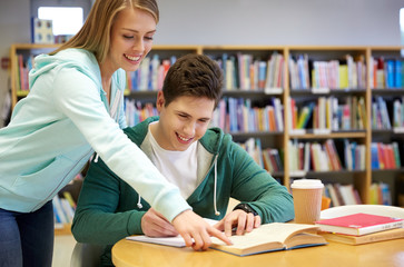 happy students preparing to exams in library