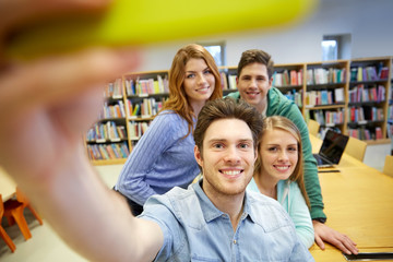 students with smartphone taking selfie in library