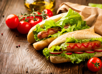 Grilled hot dogs with mustard and ketchup on a picnic wooden table