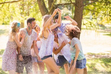 Fototapeta premium Young friends having fun with hose in the park