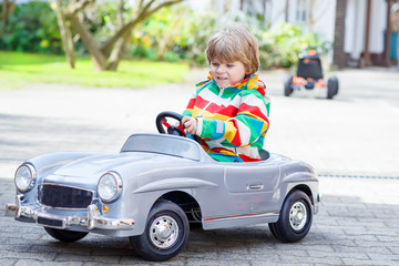 Fototapeta na wymiar Two happy sibling boys playing with big old toy car